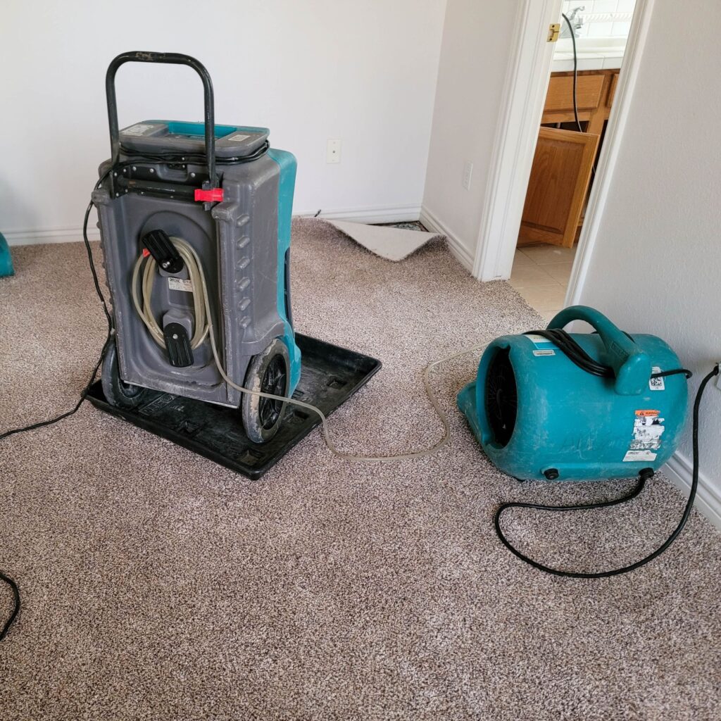 dehumidifier and air blower in carpeted bedroom